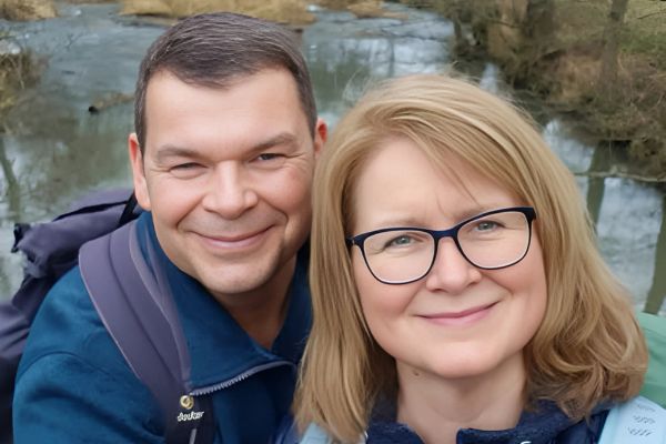 Ein roter Rucksack vor einem Stapel Brennholz